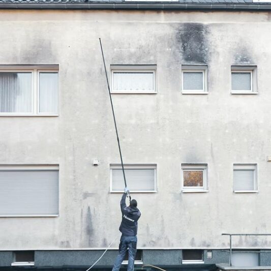 Fassadenreinigung vom Meister - die Fassade wird mit Wirkstofflösung eingesprüht.